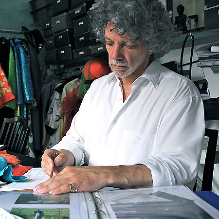 Gianni Sarto, sitzt in weißem Hemd im Atelier und entwirft einen neuen Seiden-Kimono für Design Gianni Sarto.
