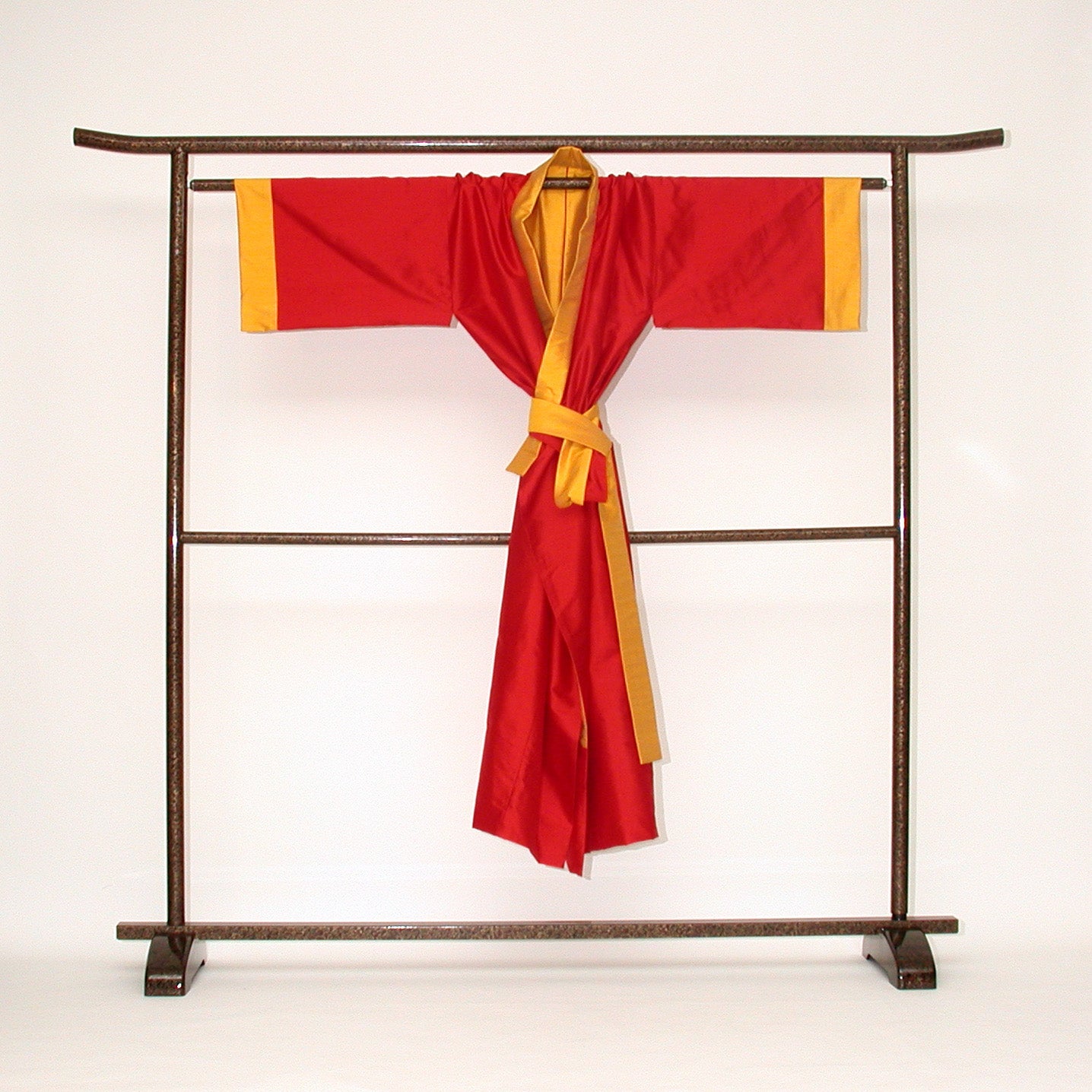 Auf einem japanischen Kimono-Ständer ein Seiden-Kimono. Er ist  wendbar, gefertigt in roter und sonnengelber Doupion-Seide. Handgefertigt Design Gianni Sarto Made in Germany