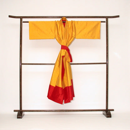 Auf einem japanischen Kimono-Ständer ein Seiden-Kimono. Er ist  wendbar, gefertigt in sonnengelber und roter  Doupion-Seide. Handgefertigt Design Gianni Sarto Made in Germany